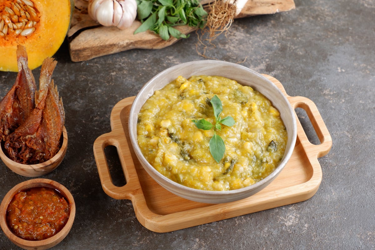 Bubur Manado or Tinutuan porridge. Indonesian food - Manado traditional rice porridge, mixed with pumpkin, corn, vegetables. Served with salted fish and sambal or chili sauce